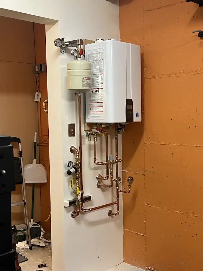 Plumbing technician inspecting water heater connections in Callicoon